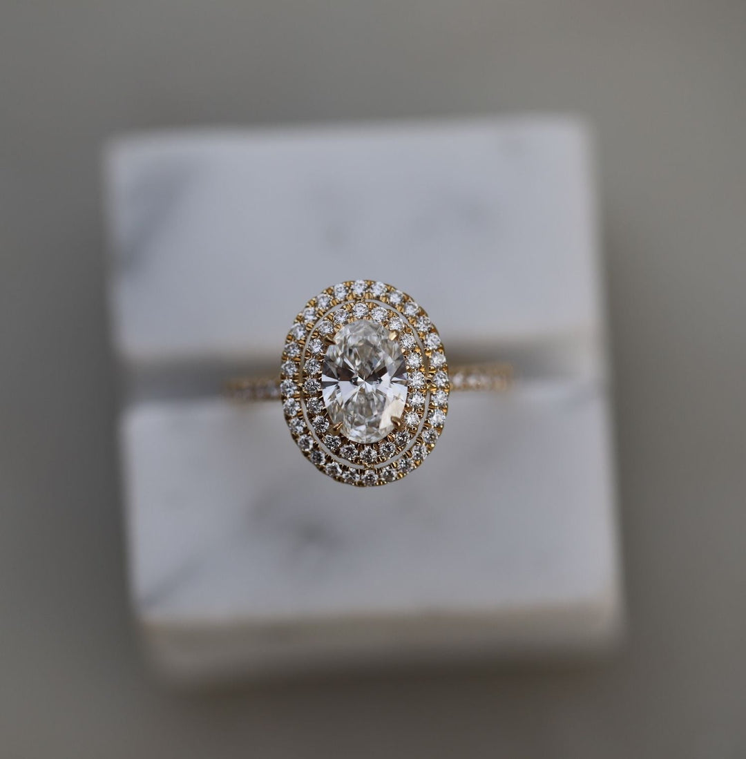 Oval halo engagement ring viewed from the side