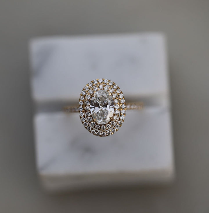 Oval halo engagement ring viewed from the side