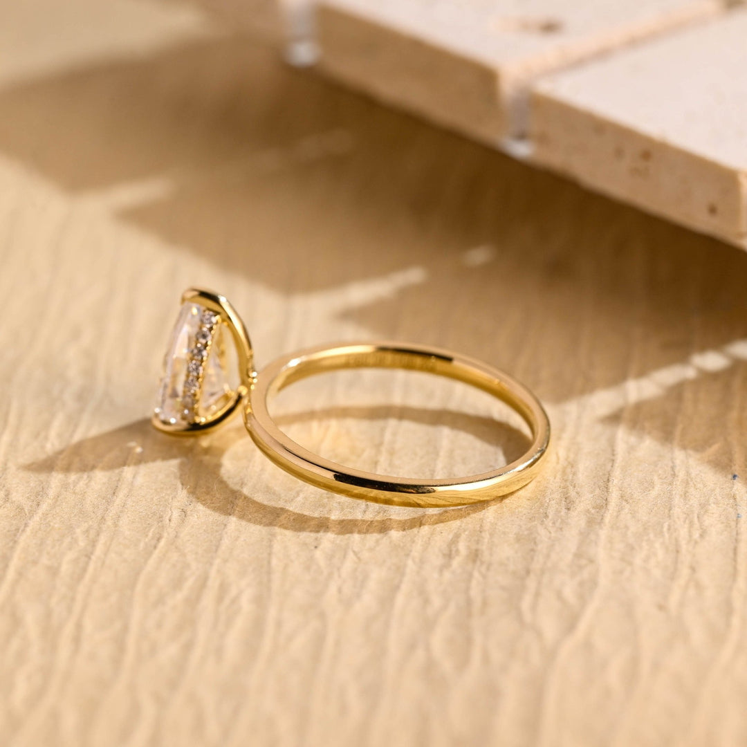 Pear hidden halo engagement ring photographed in natural light