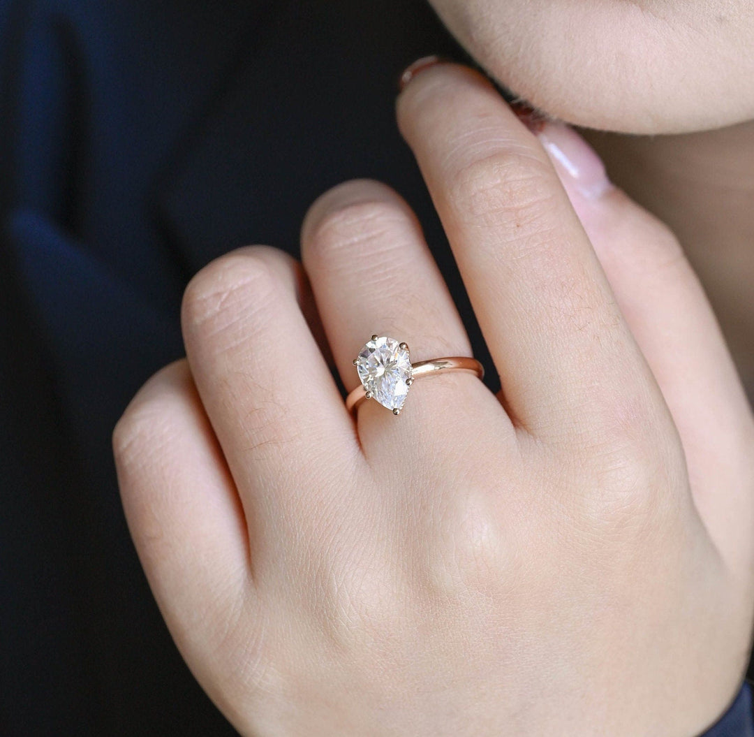Pear hidden halo engagement ring finished in polished solid gold