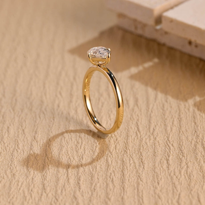 Pear east west diamond ring displayed on jewelry stand