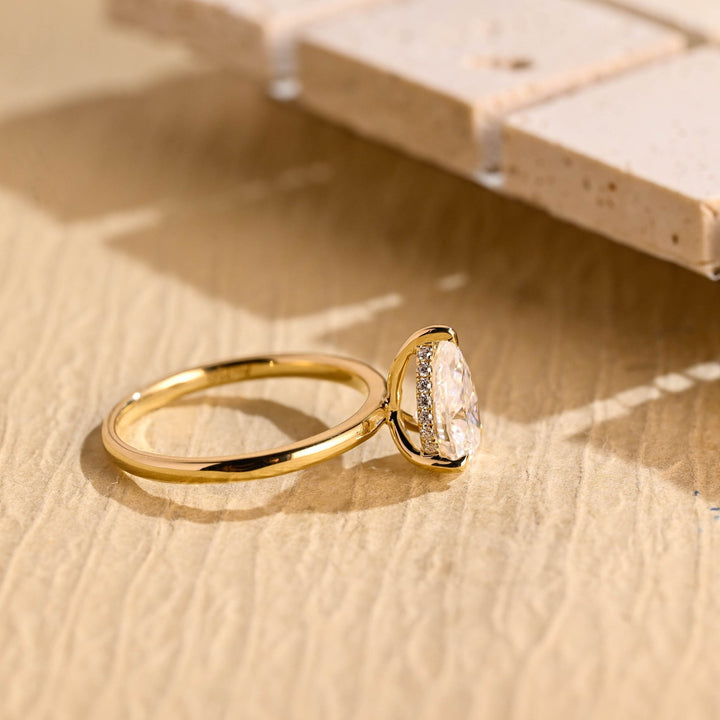 Pear hidden halo diamond ring displayed on jewelry stand