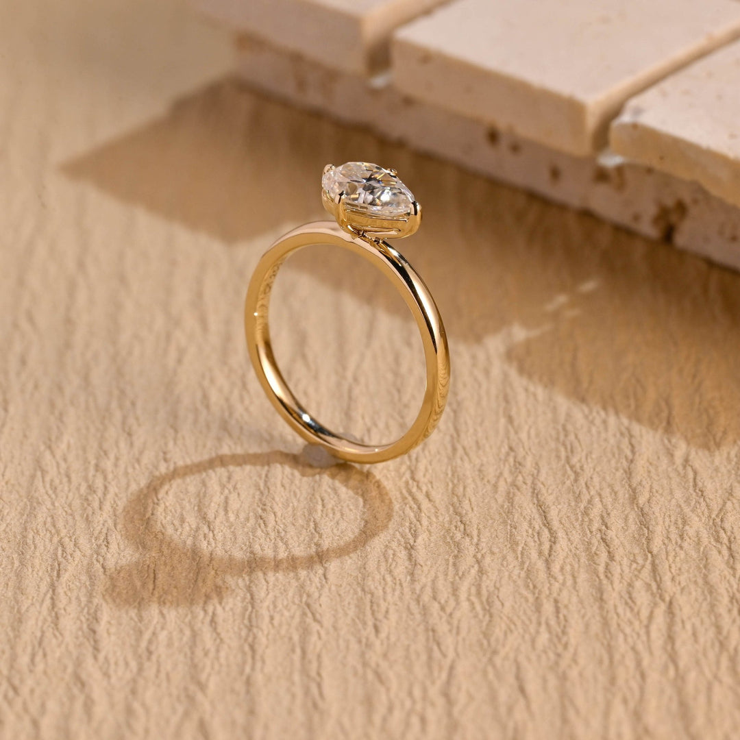 Pear east west engagement ring finished in polished solid gold
