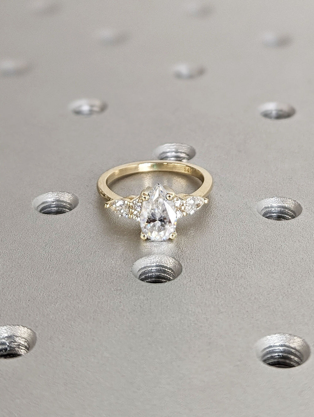 Profile view of pear cut cluster engagement ring band
