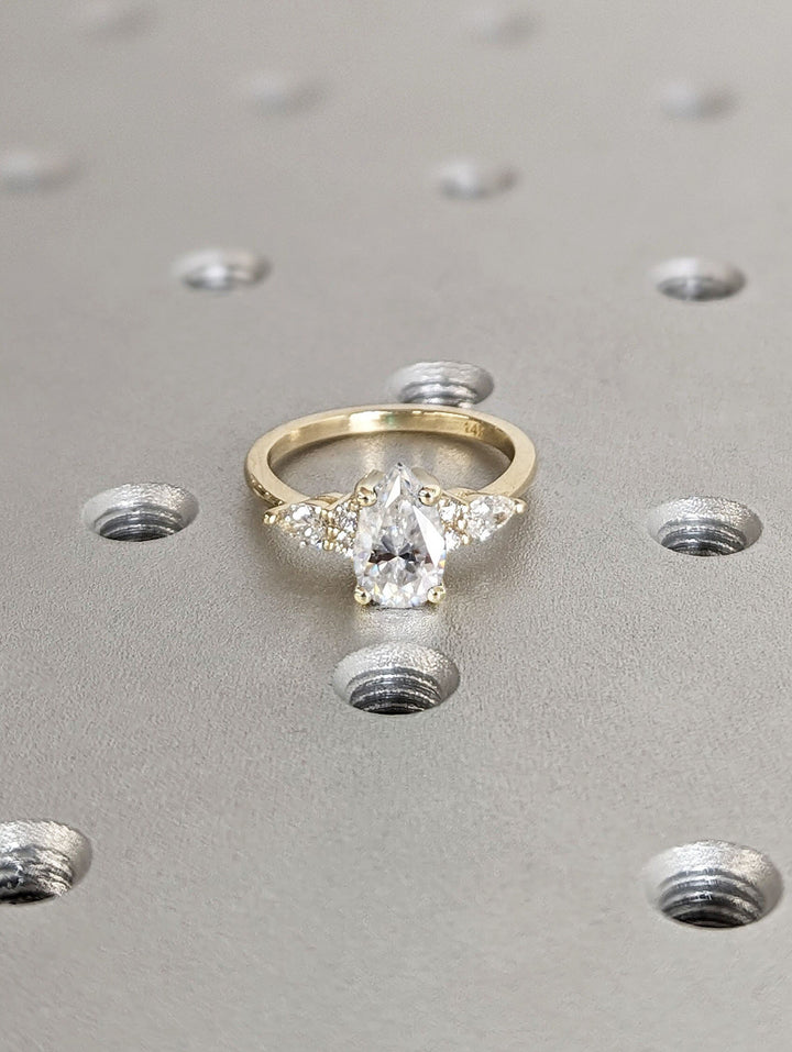 Profile view of pear cut cluster engagement ring band