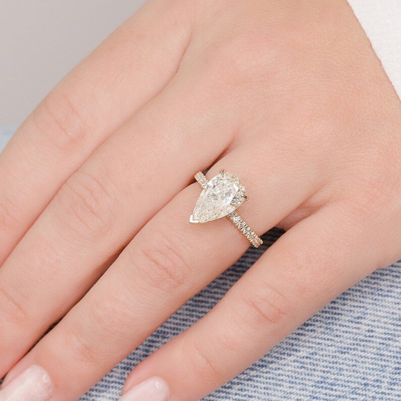 Profile view of pear cut hidden halo engagement ring band