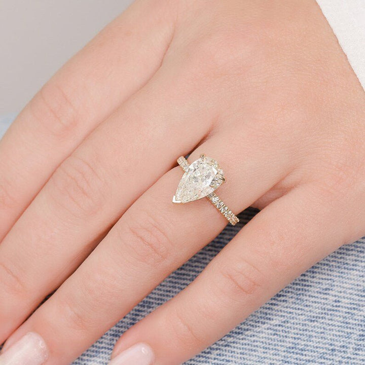 Profile view of pear cut hidden halo engagement ring band