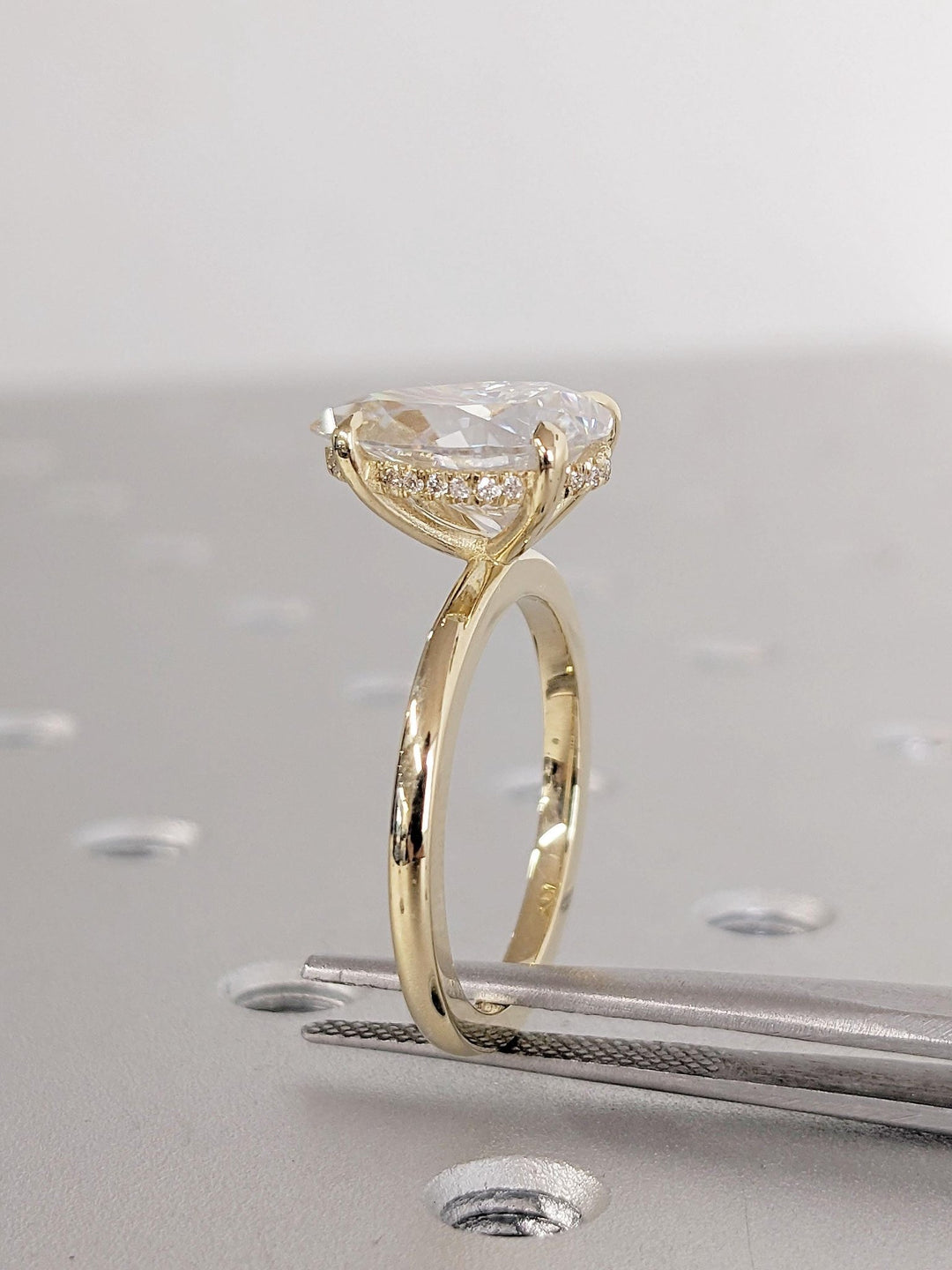 Pear cut engagement ring shown with authenticity certificate