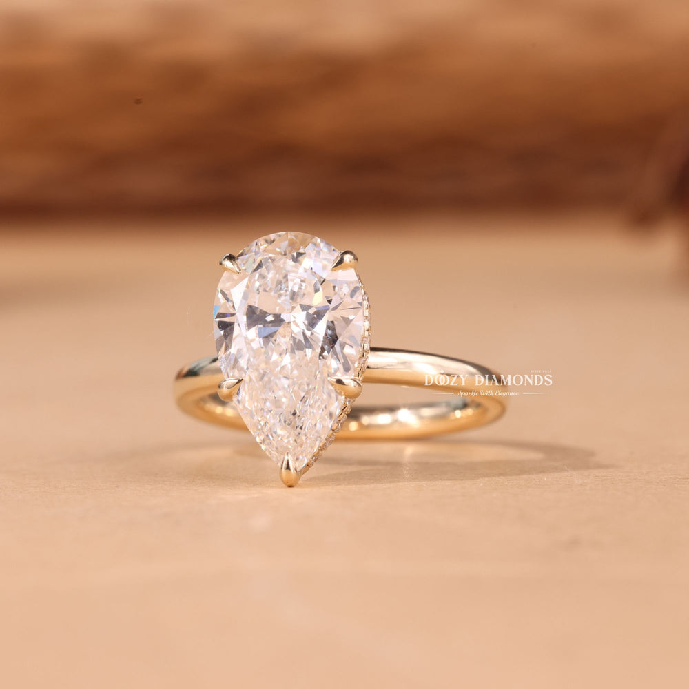 Pear hidden halo engagement ring finished in polished solid gold