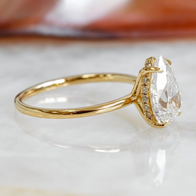 Certified pear cut diamond featured in hidden halo engagement ring