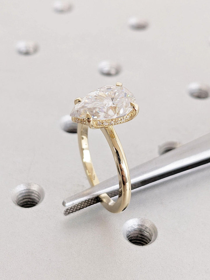 Pear hidden halo diamond engagement ring available in multiple metals