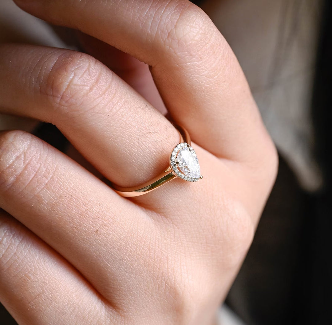 Pear halo diamond ring displayed on jewelry stand