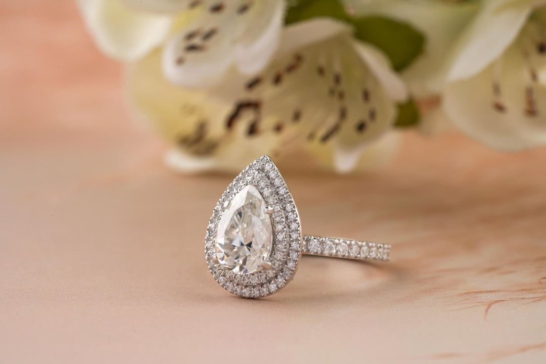 Macro shot of pear cut diamond facets in halo ring setting
