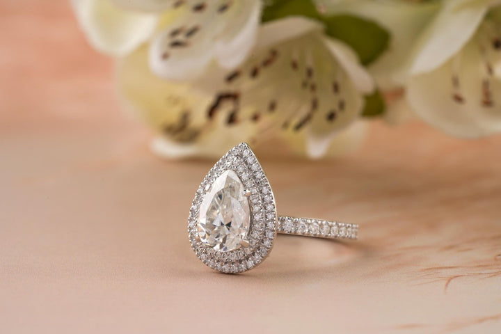 Macro shot of pear cut diamond facets in halo ring setting