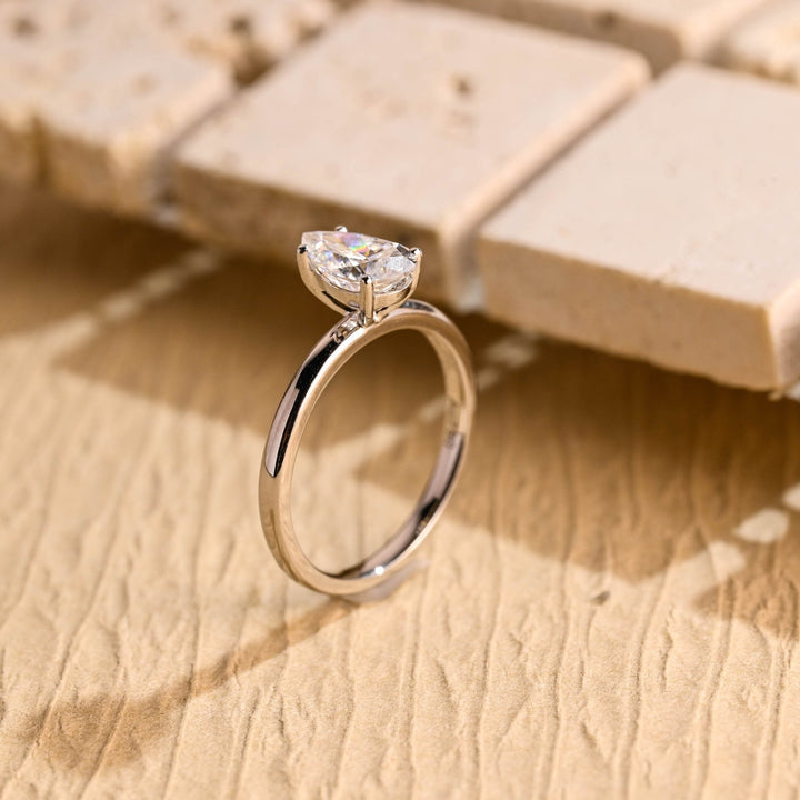Pear solitaire diamond ring displayed on jewelry stand