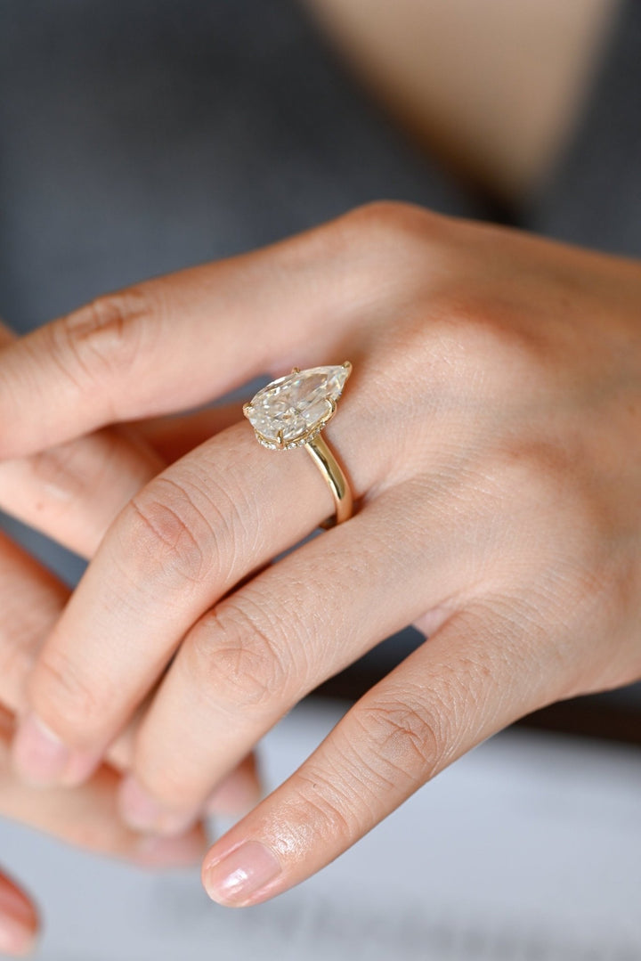 Pear hidden halo engagement ring shown on hand for true-to-life sizing
