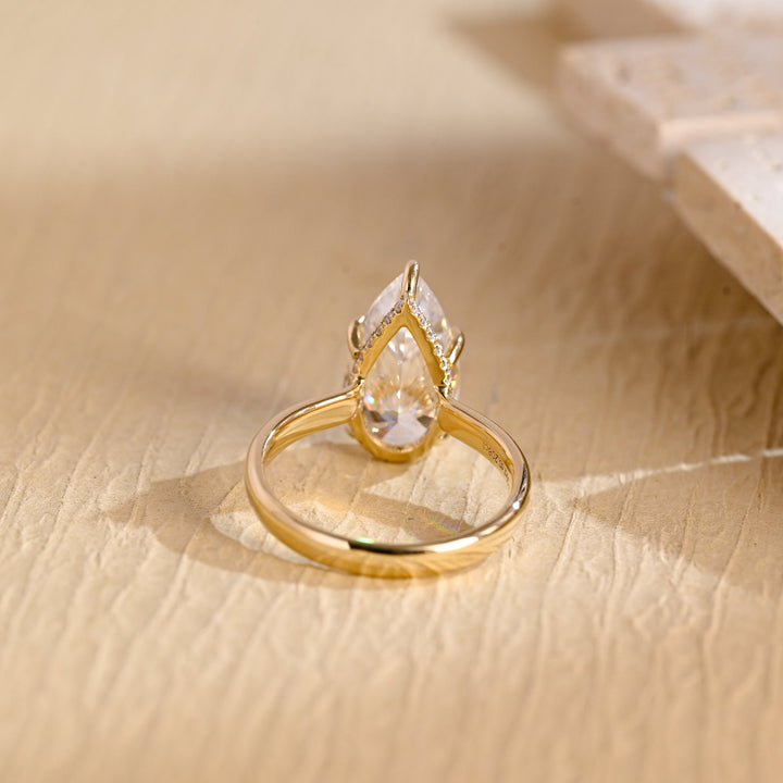 Detailed close-up of pear hidden halo diamond engagement ring