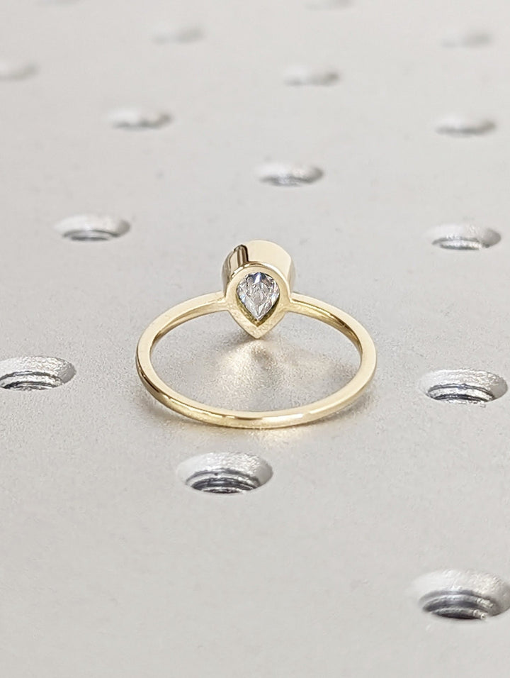 Pear bezel engagement ring photographed in natural light