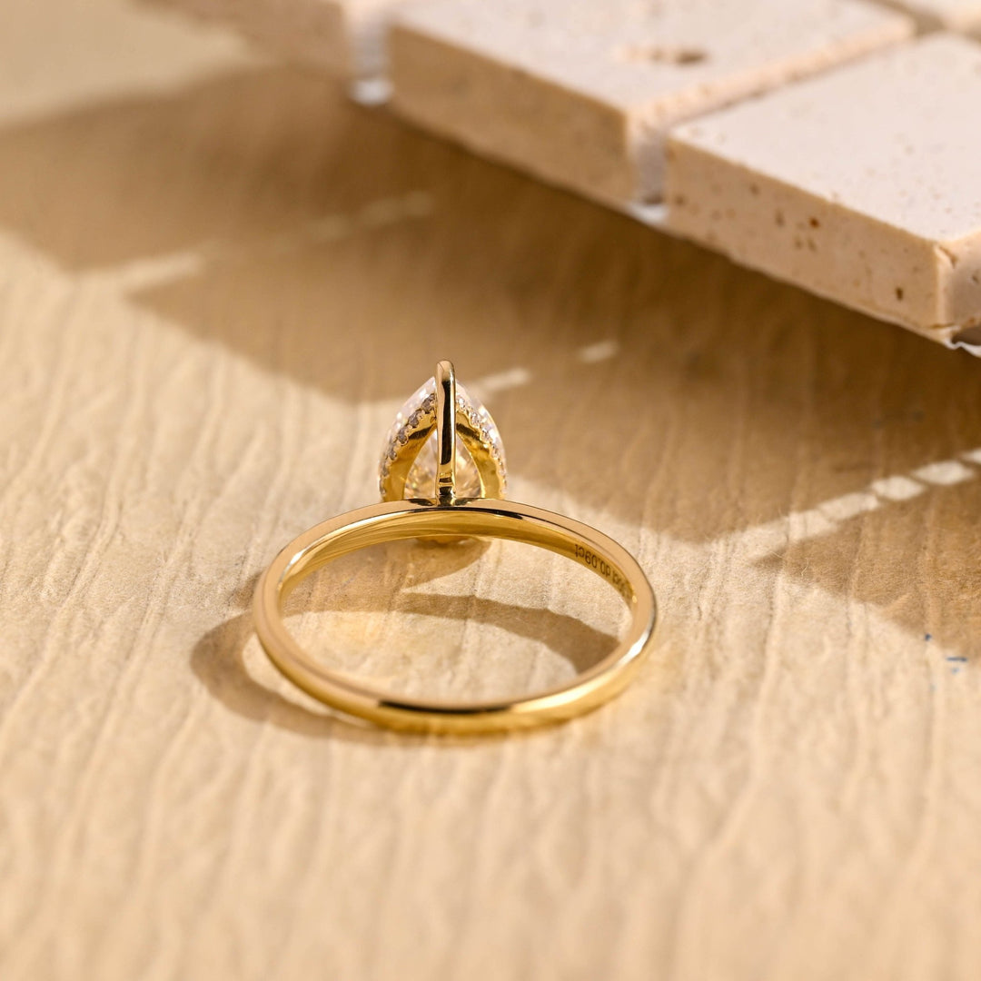 Pear hidden halo engagement ring finished in polished solid gold