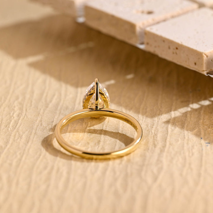 Pear hidden halo engagement ring finished in polished solid gold