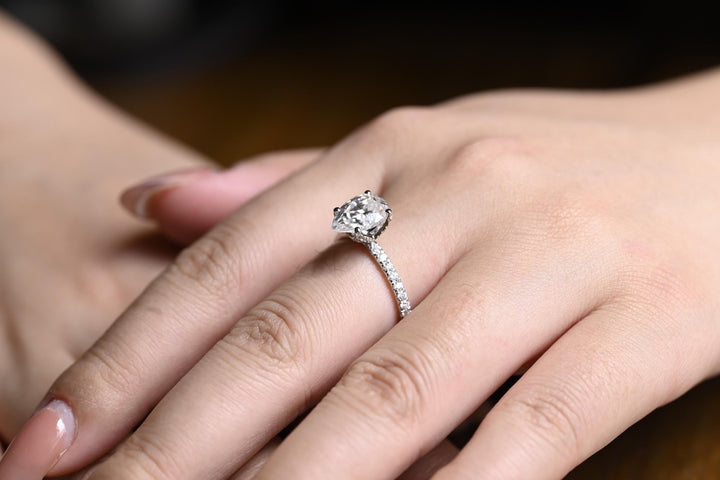 Detailed close-up of pear hidden halo diamond engagement ring