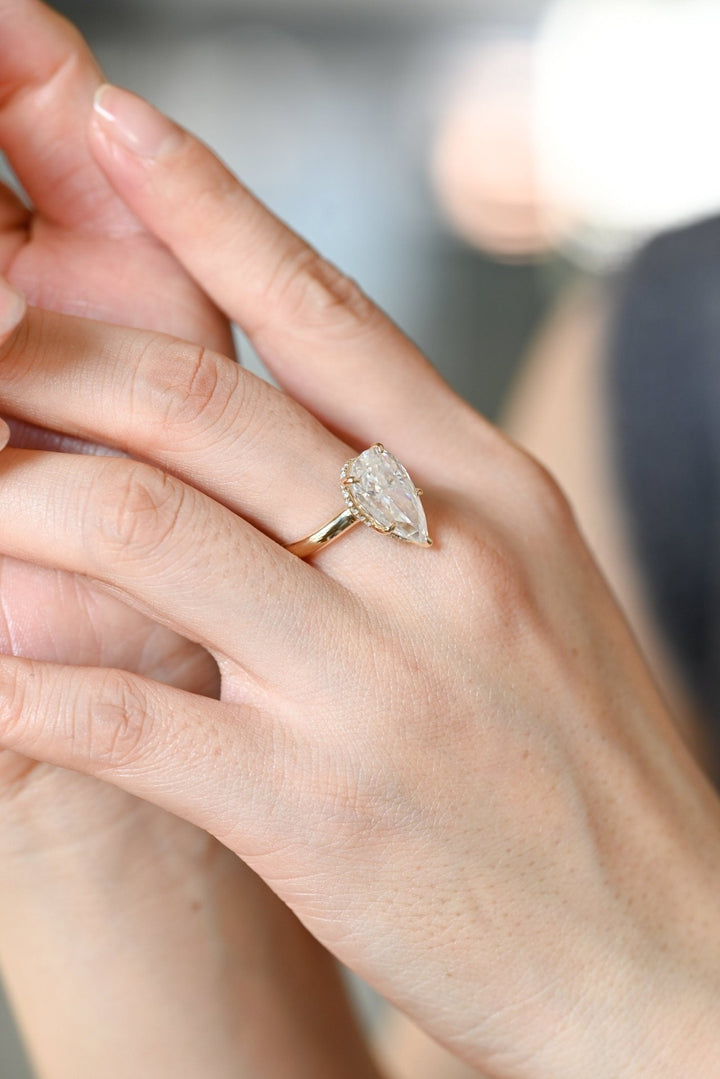 Profile view of pear cut hidden halo engagement ring band