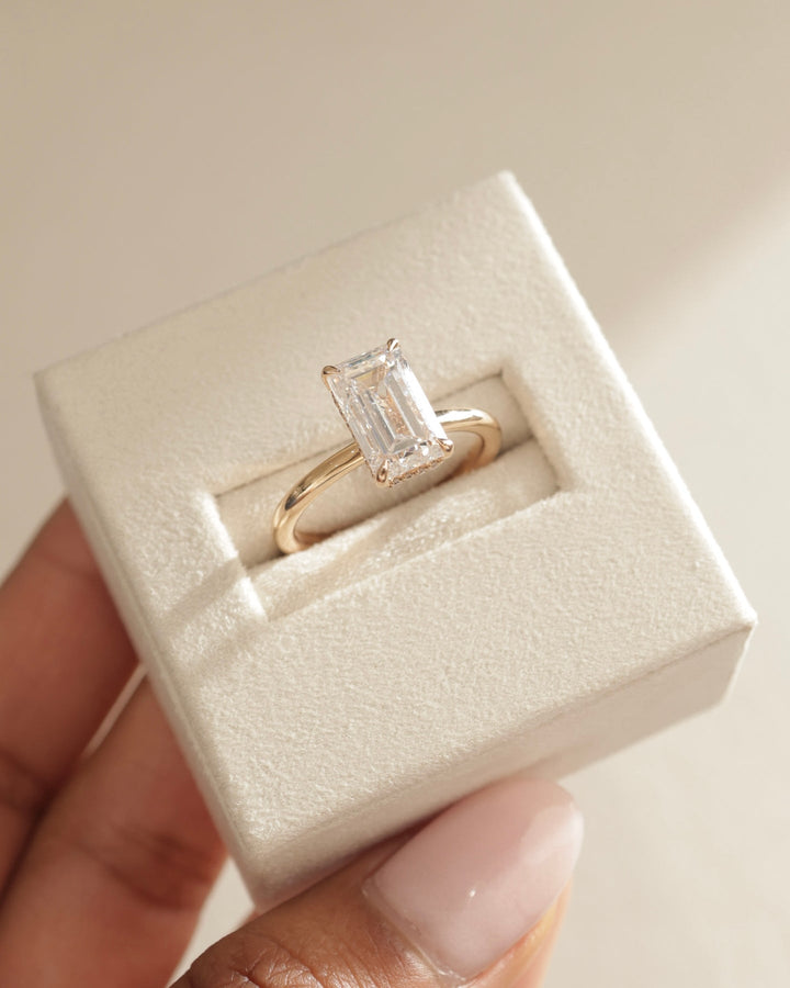 Emerald hidden halo engagement ring close-up highlighting diamond sparkle