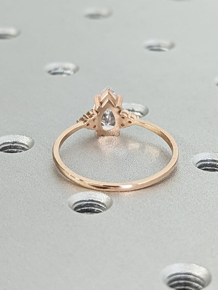 Pear cluster engagement ring finished in polished solid gold