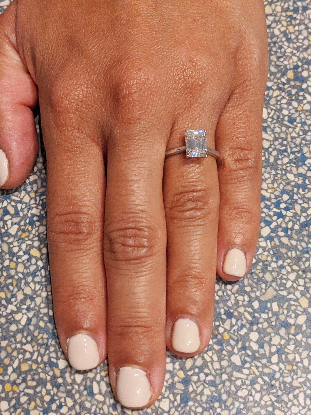 Emerald solitaire engagement ring photographed in natural light