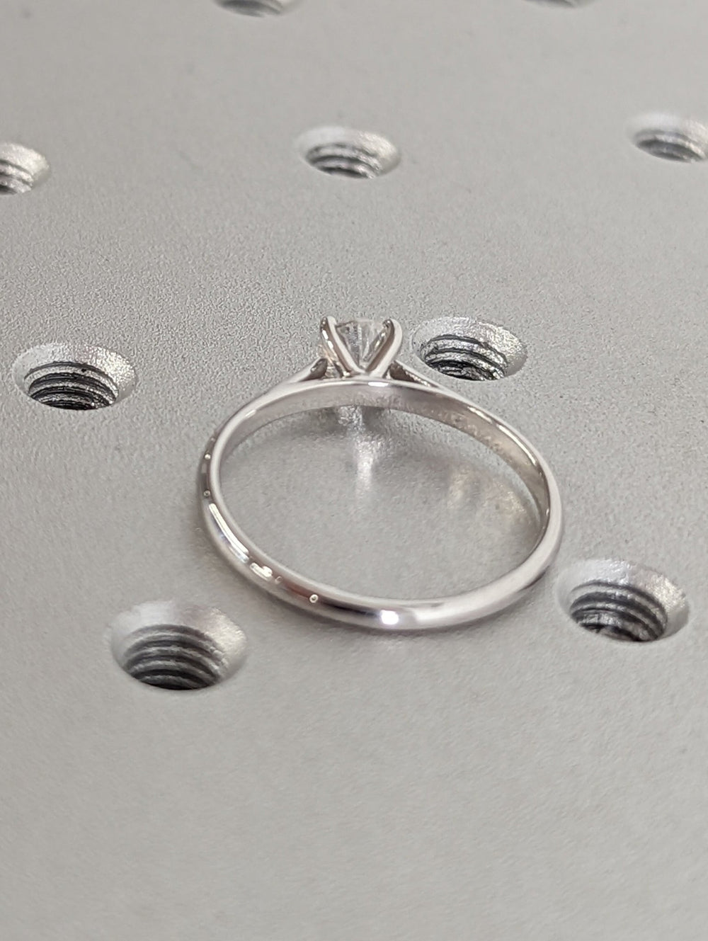 Side angle of round solitaire diamond engagement ring