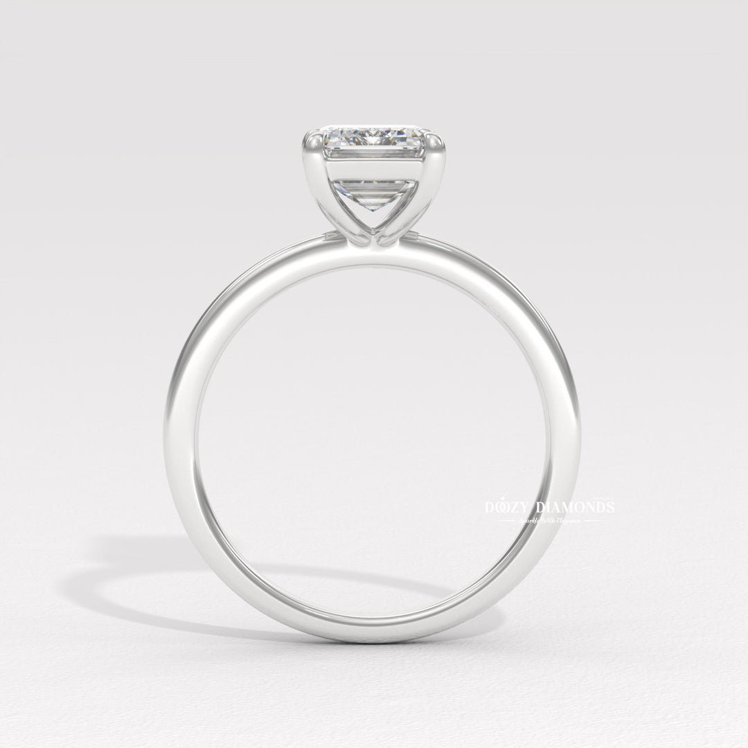Emerald solitaire diamond ring displayed on jewelry stand