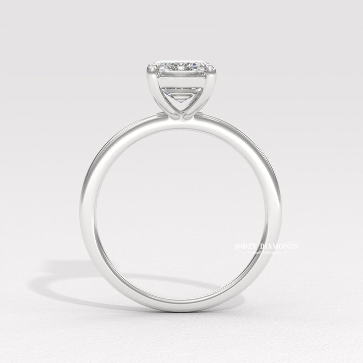 Emerald solitaire diamond ring displayed on jewelry stand