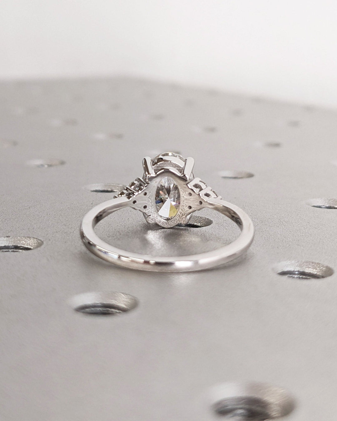 Detailed close-up of oval cluster diamond engagement ring