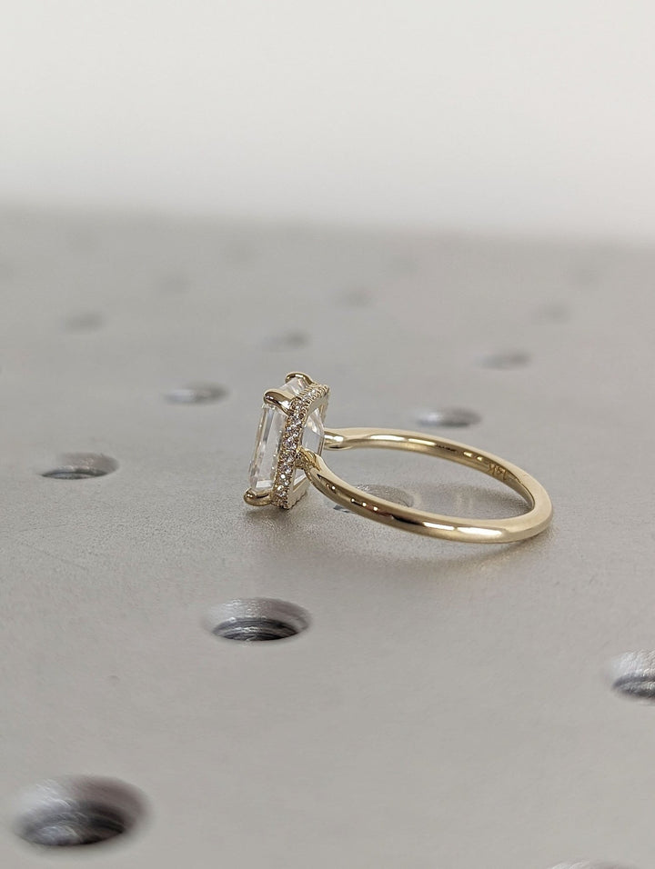 Side angle of emerald hidden halo diamond engagement ring