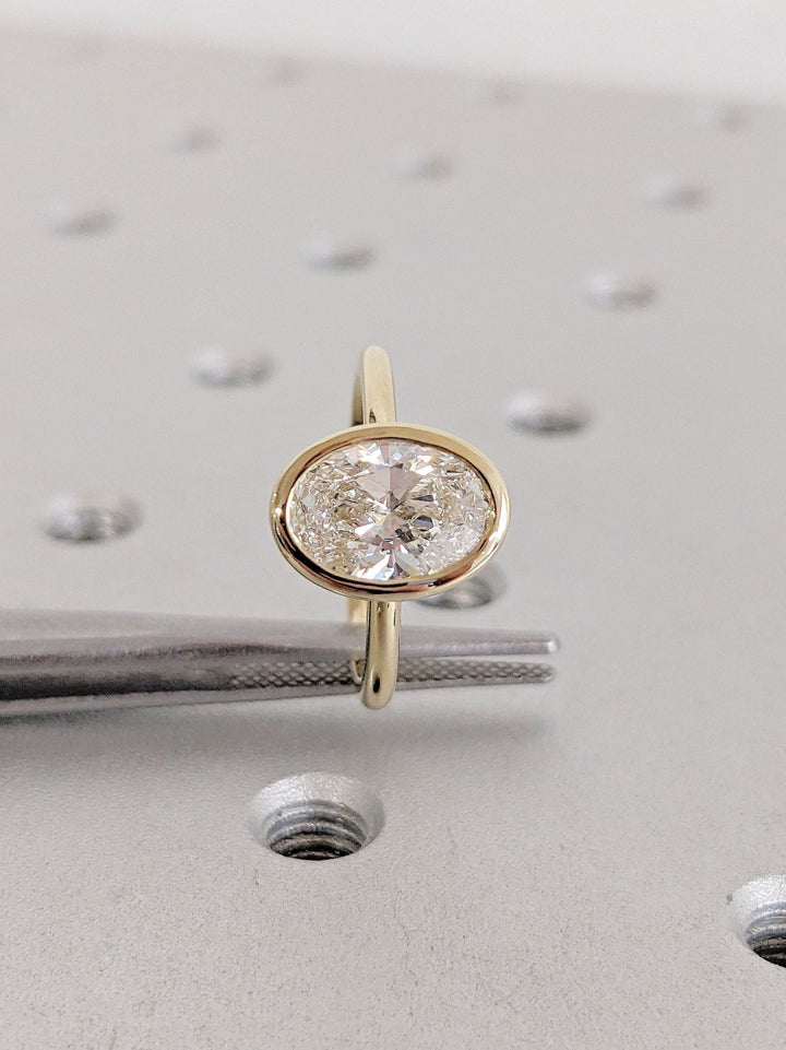 Macro shot of oval cut diamond facets in bezel ring setting