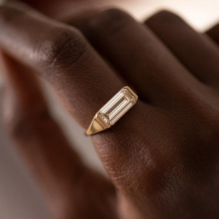 Side angle of emerald east west diamond engagement ring