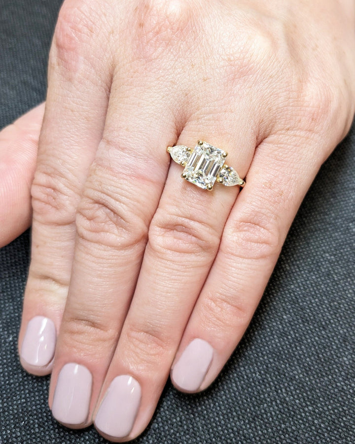 Emerald three stone engagement ring viewed from the side