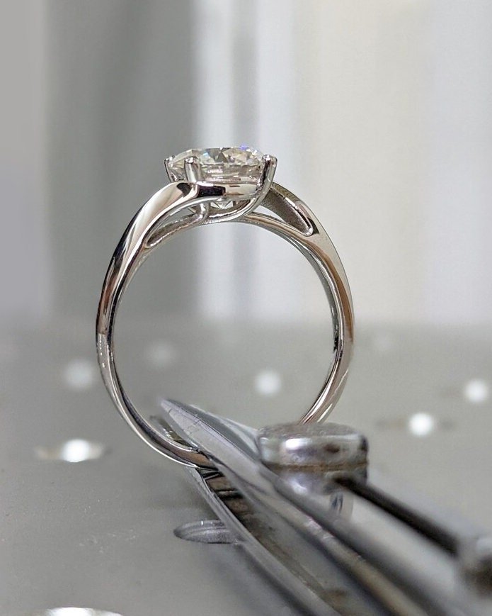 Lifestyle shot of round solitaire diamond ring on hand