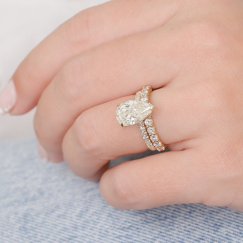 Pear hidden halo engagement ring shown on hand for true-to-life sizing