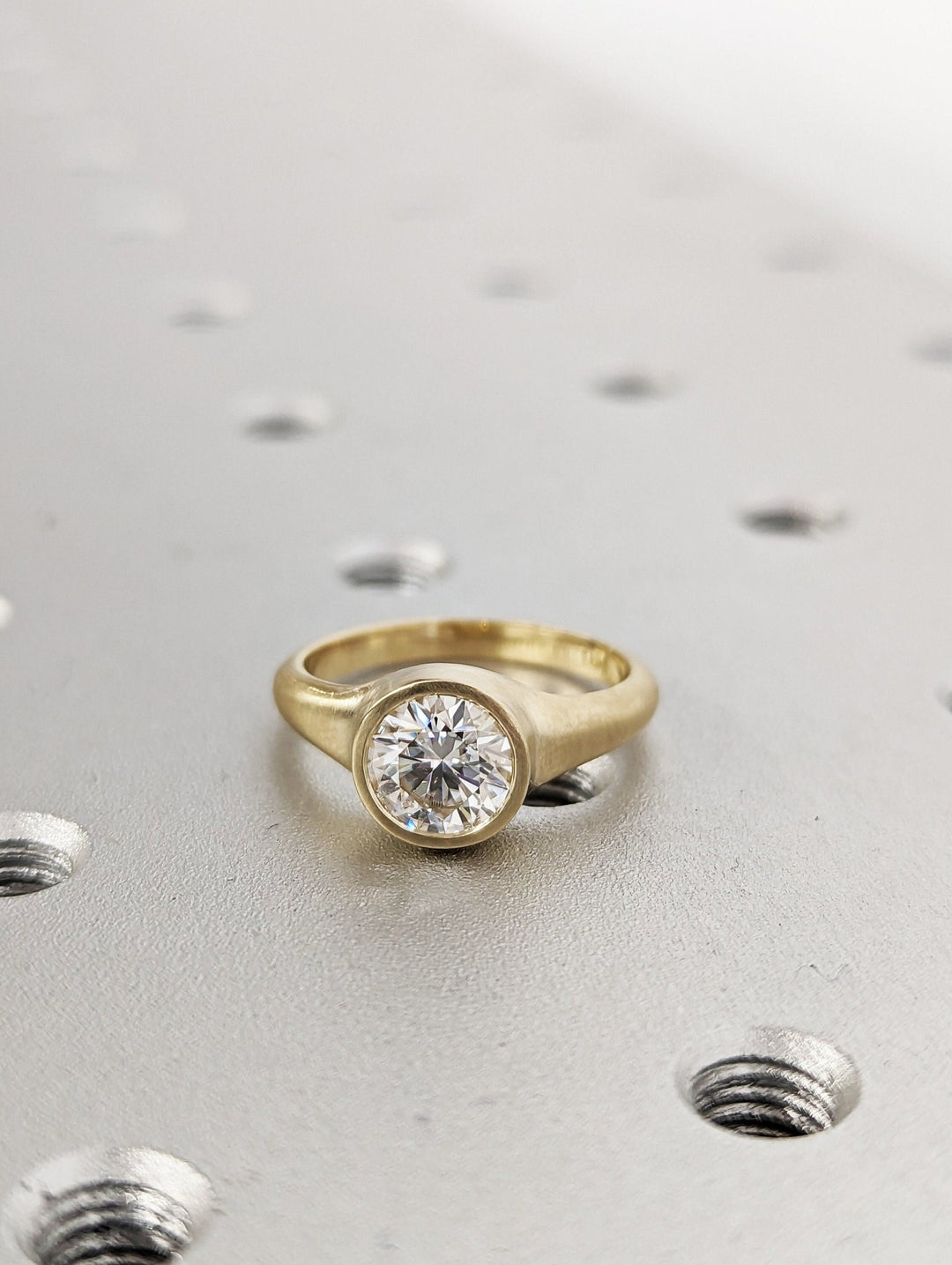Profile view of round cut bezel engagement ring band
