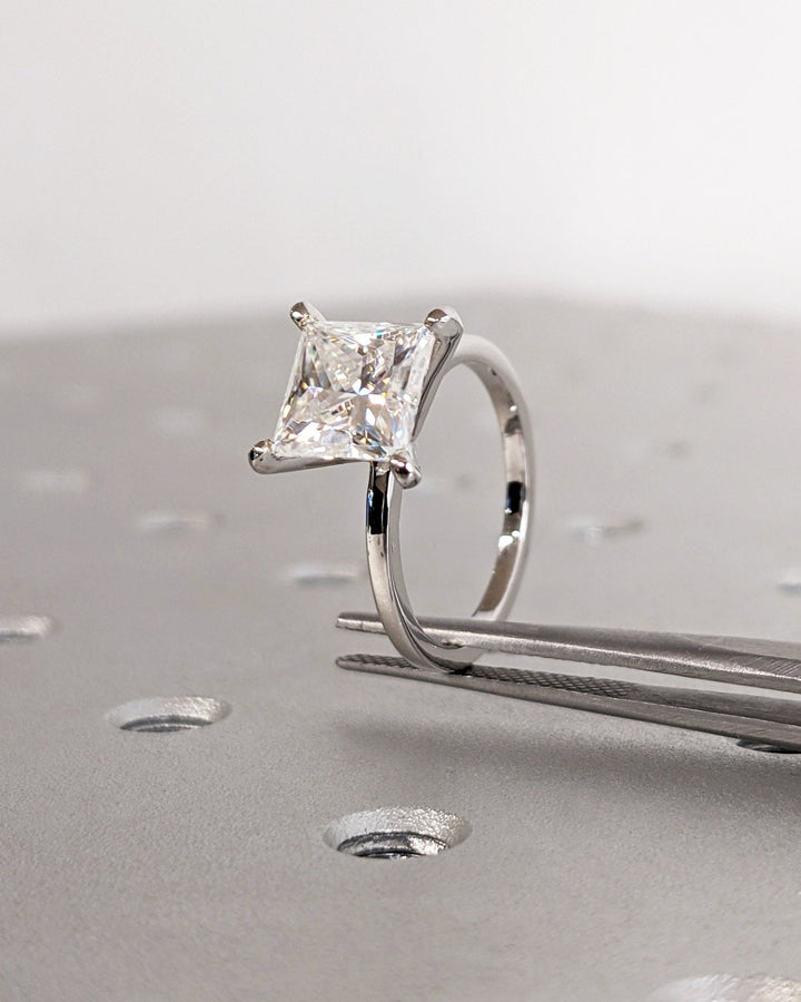 Princess cut engagement ring shown with authenticity certificate
