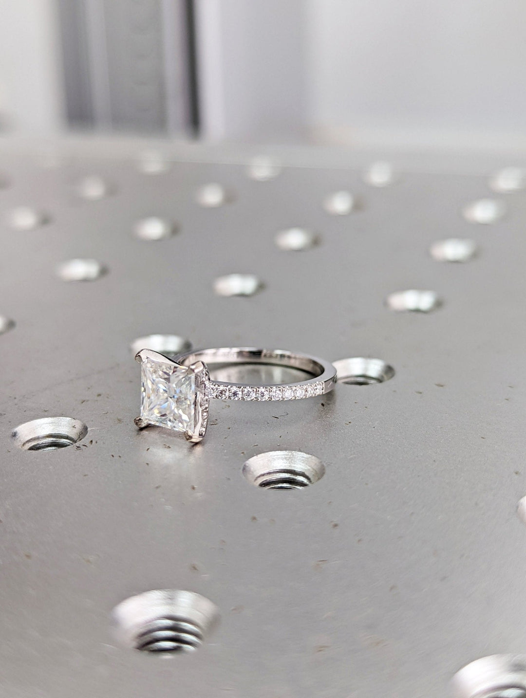 Close-up of princess cut center diamond in pave engagement ring