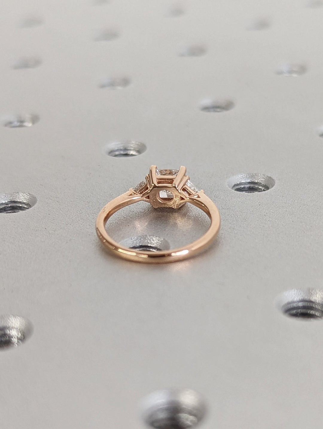 Top-down view of princess cut three stone engagement ring