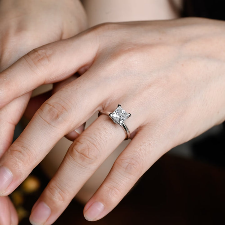 Princess solitaire diamond ring displayed on jewelry stand