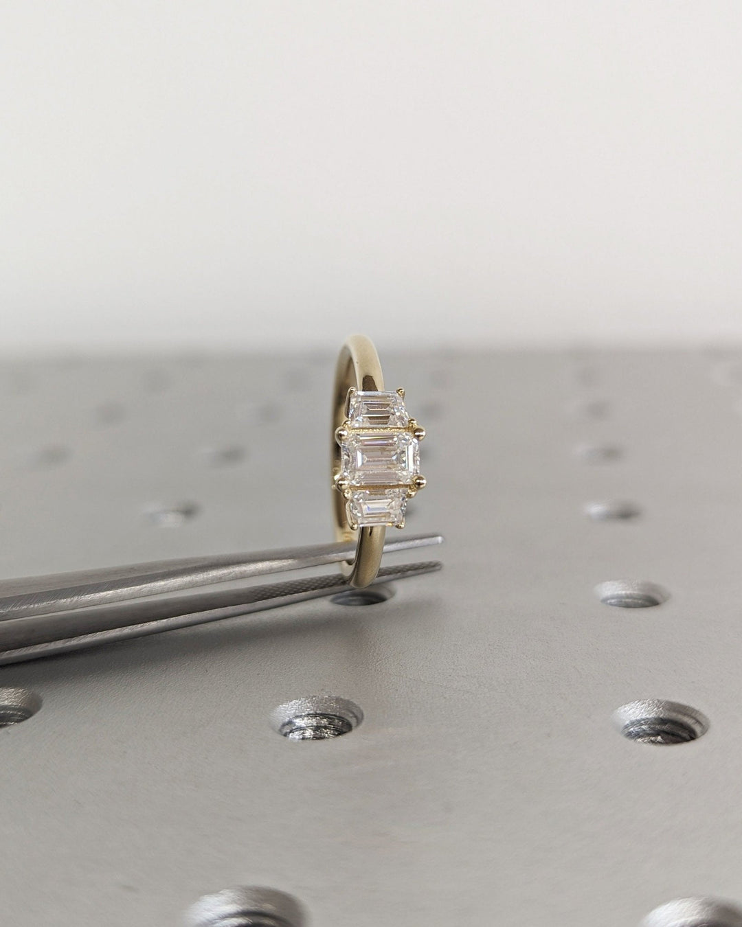 Unboxing view of emerald cut three stone diamond engagement ring