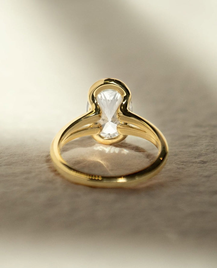 Angled view of oval cut diamond in bezel setting