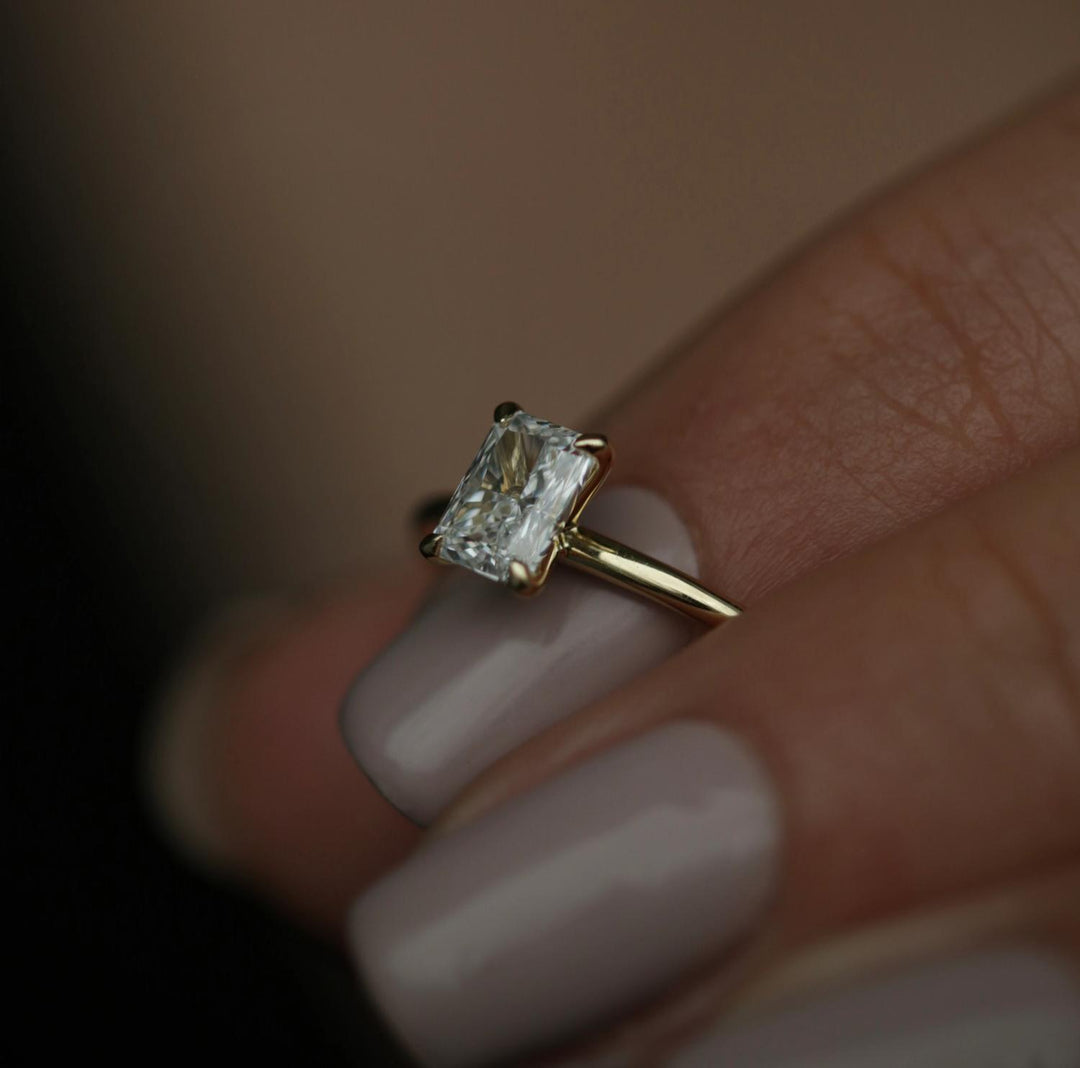 Radiant solitaire engagement ring shown on hand for true-to-life sizing