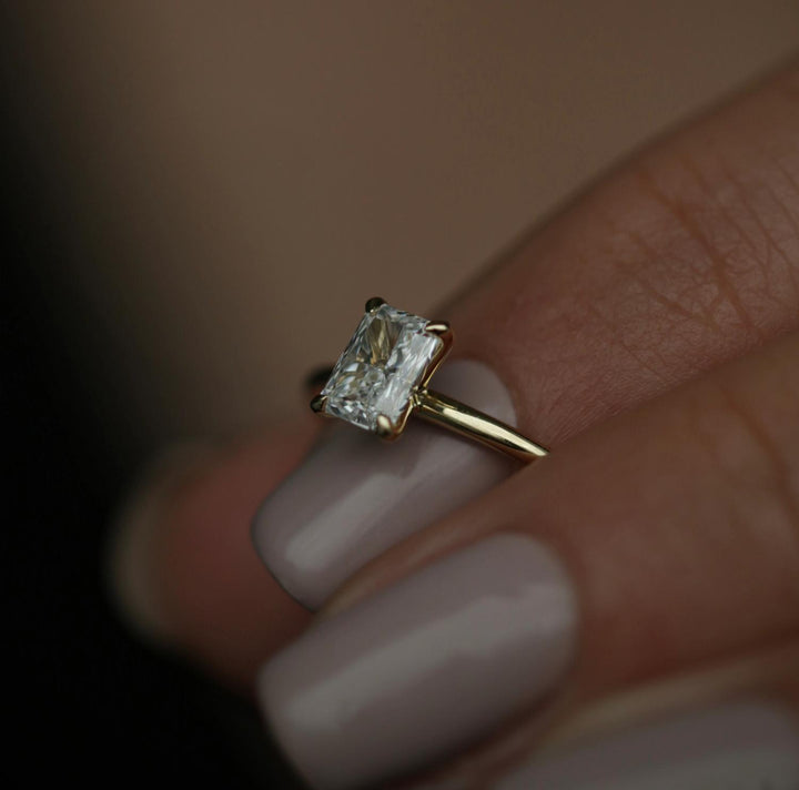 Radiant solitaire engagement ring shown on hand for true-to-life sizing