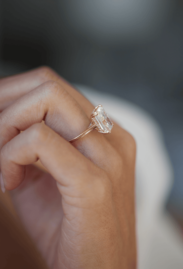 Radiant hidden halo engagement ring shown on hand for true-to-life sizing