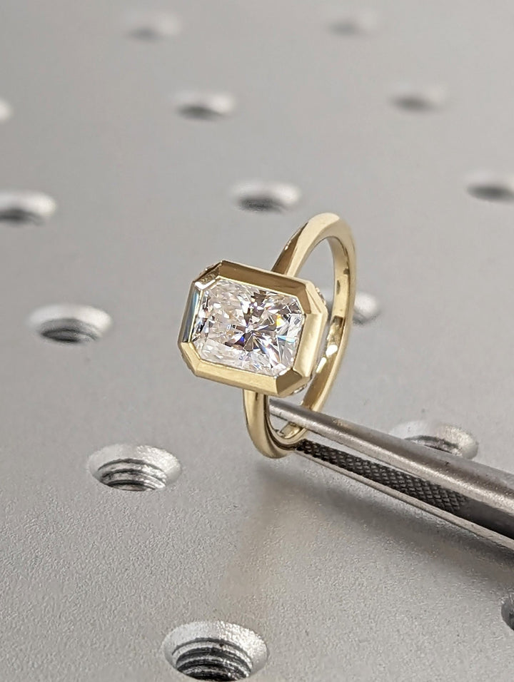Radiant hidden halo engagement ring finished in polished solid gold
